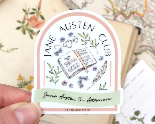 Image of a Vinyl Sticker in an Arched Badge shape with 'Jane Austen Club' written on it along with illustrations of a book, spectacles, quill, florals and a latin moto.