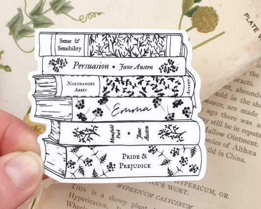 Image of a die cut vinyl sticker featuring a bookstack of Jane Austen's most famous works in black line art with floral decoration.